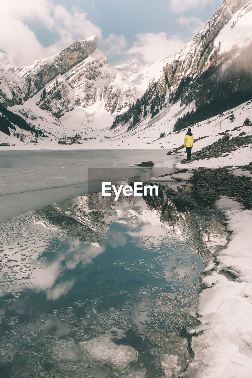 Scenic view of lake by mountains against sky