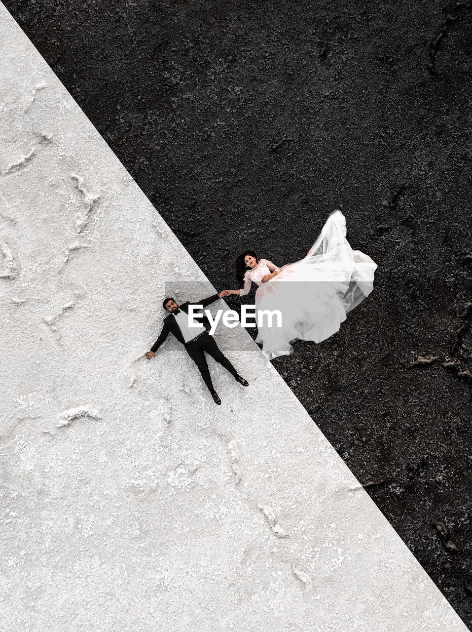 Directly above shot of bride and bridegroom lying on floor