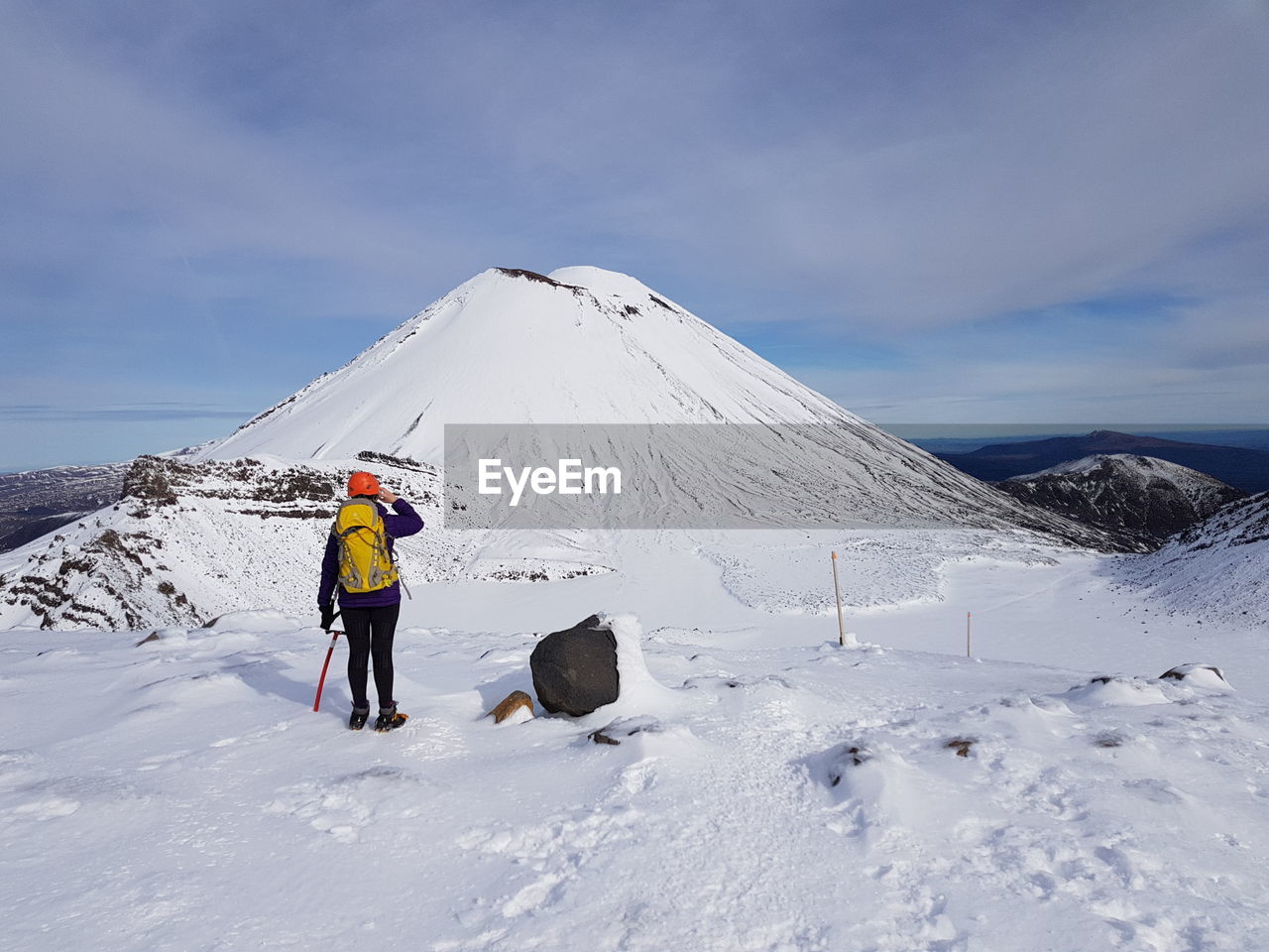 Rear view of man on snowcapped mountain against sky