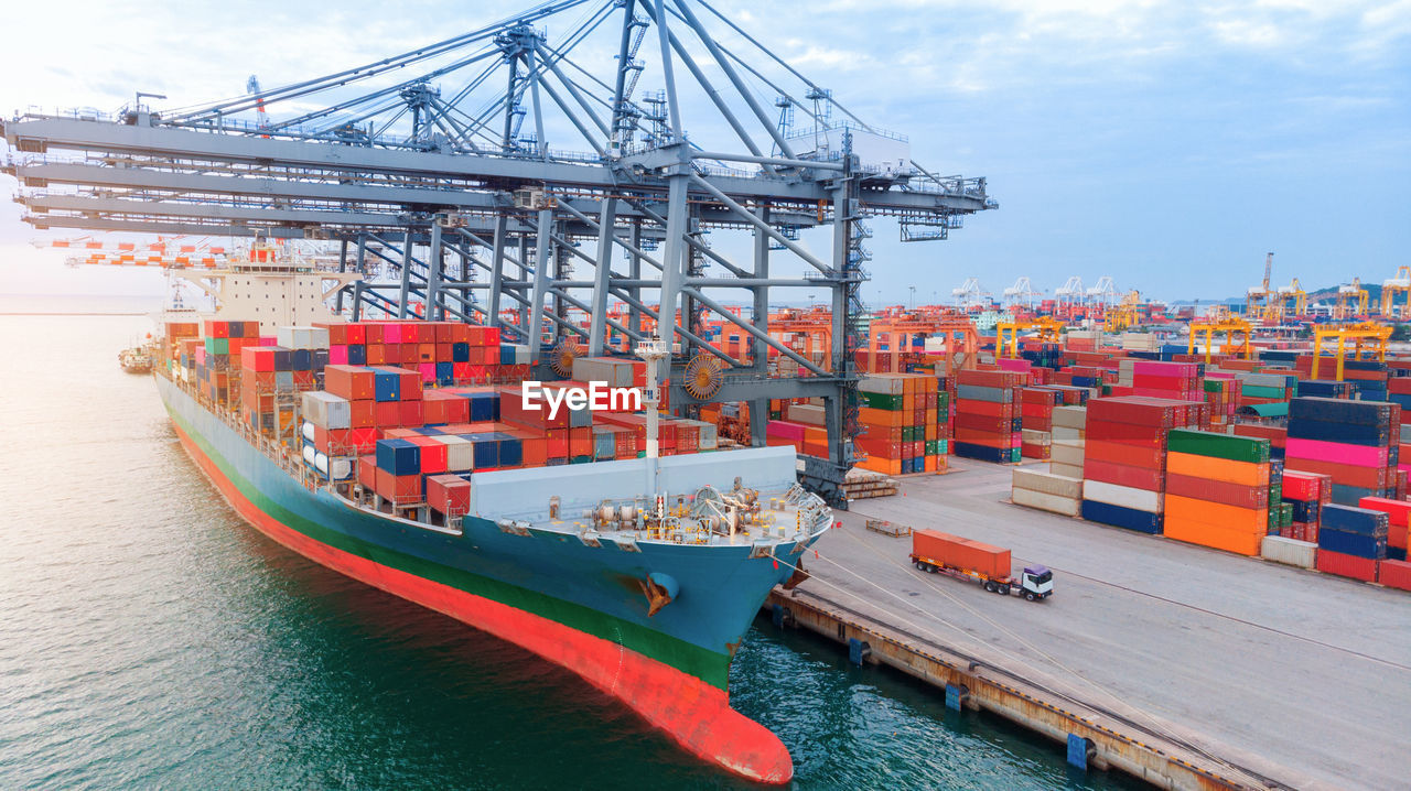 Aerial of cargo container ship carrying container under big crane loading cargo import and export 