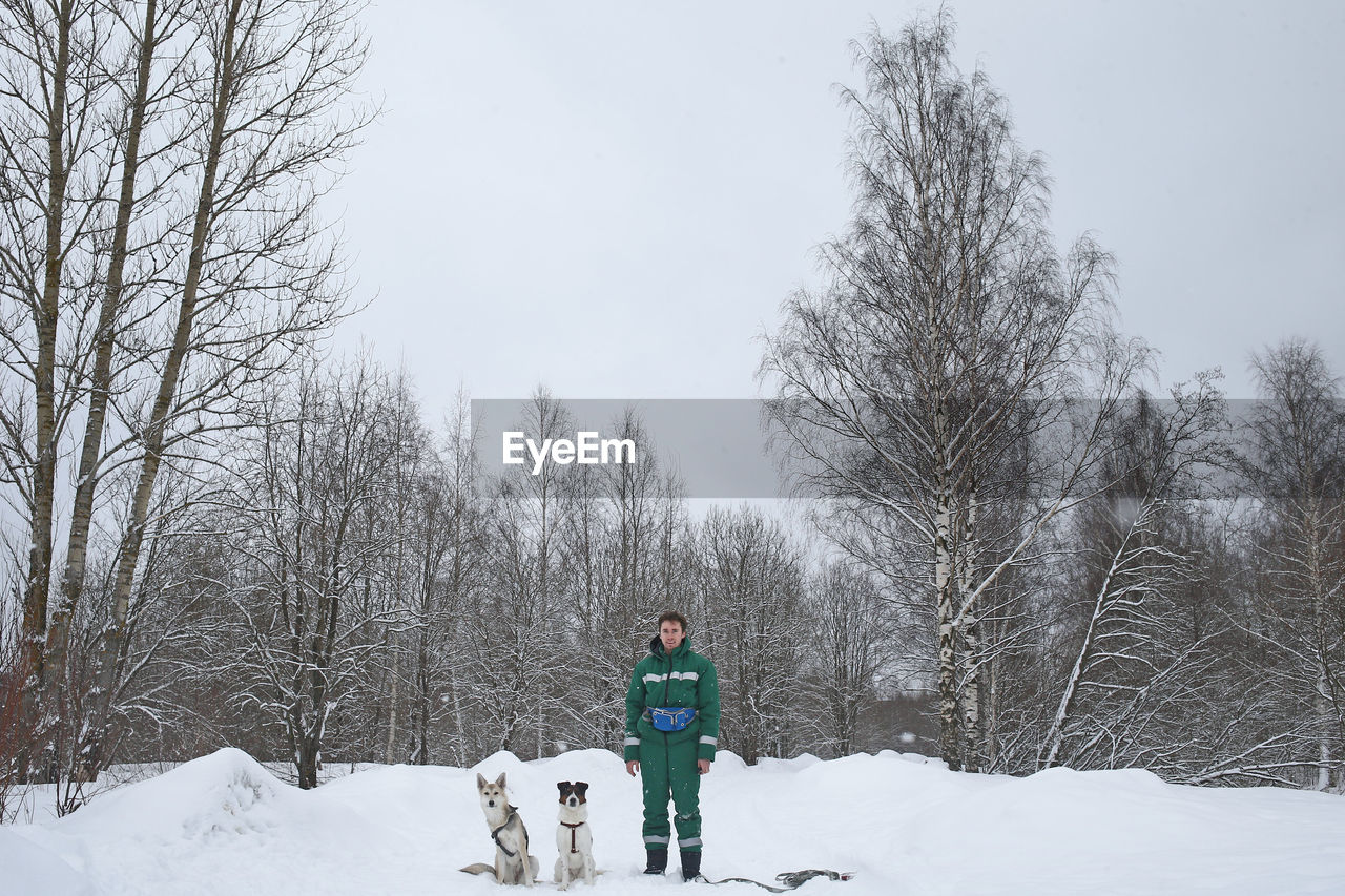 FULL LENGTH OF PERSON STANDING ON SNOW COVERED LAND