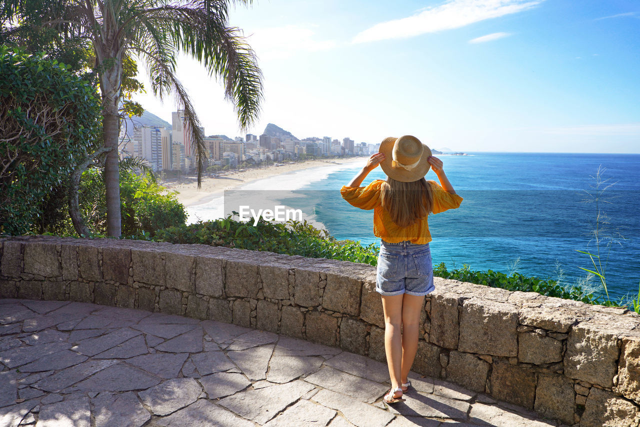 Full length of beautiful fashion girl enjoying view of rio de janeiro beaches of leblon and ipanema