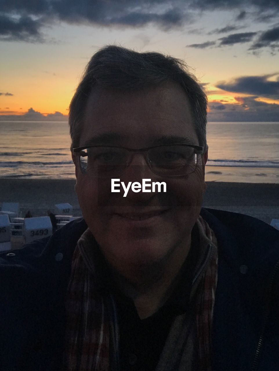 PORTRAIT OF MAN WEARING SUNGLASSES AT BEACH AGAINST SKY