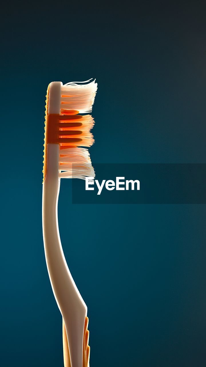 Close-up of toothbrush against blue background