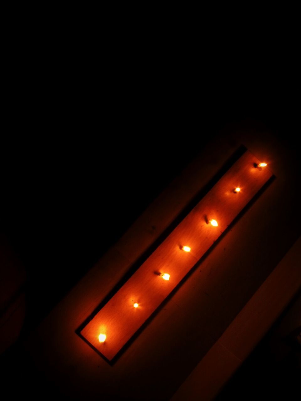 LOW ANGLE VIEW OF ILLUMINATED LIGHTS IN DARK
