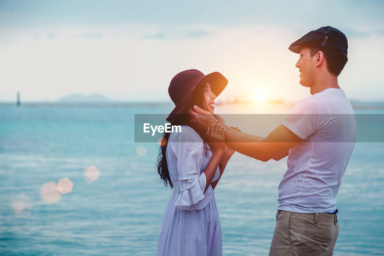 Smiling romantic couple standing at beach