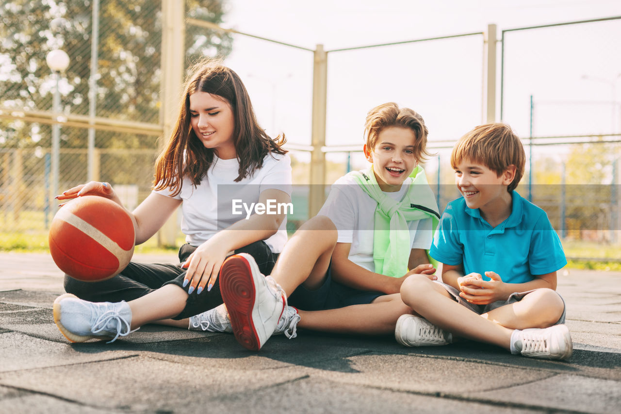 Portrait of teenagers sitting on a basketball court. children relax 