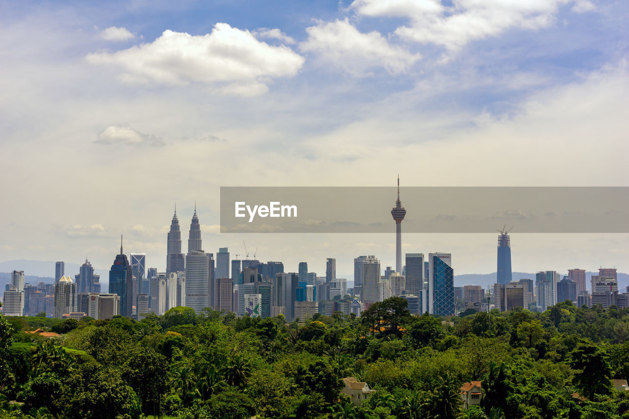 View of cityscape against cloudy sky