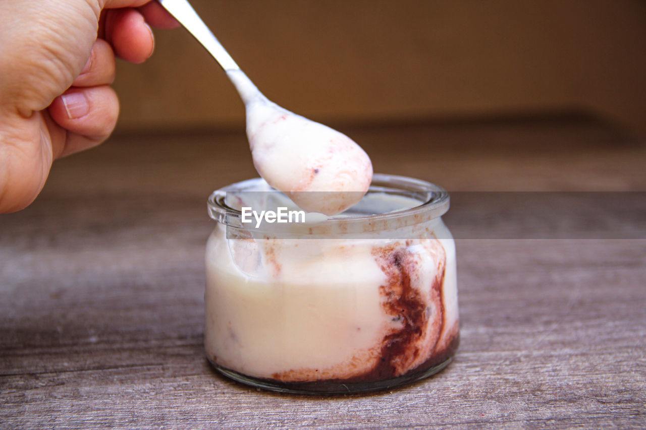 CLOSE-UP OF HAND HOLDING ICE CREAM