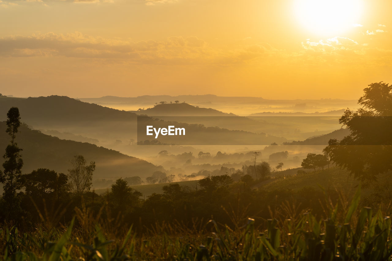 Scenic view of landscape against sky during sunrise