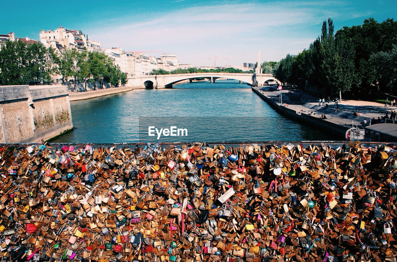 High angle view of padlocks on bridge railing against sky