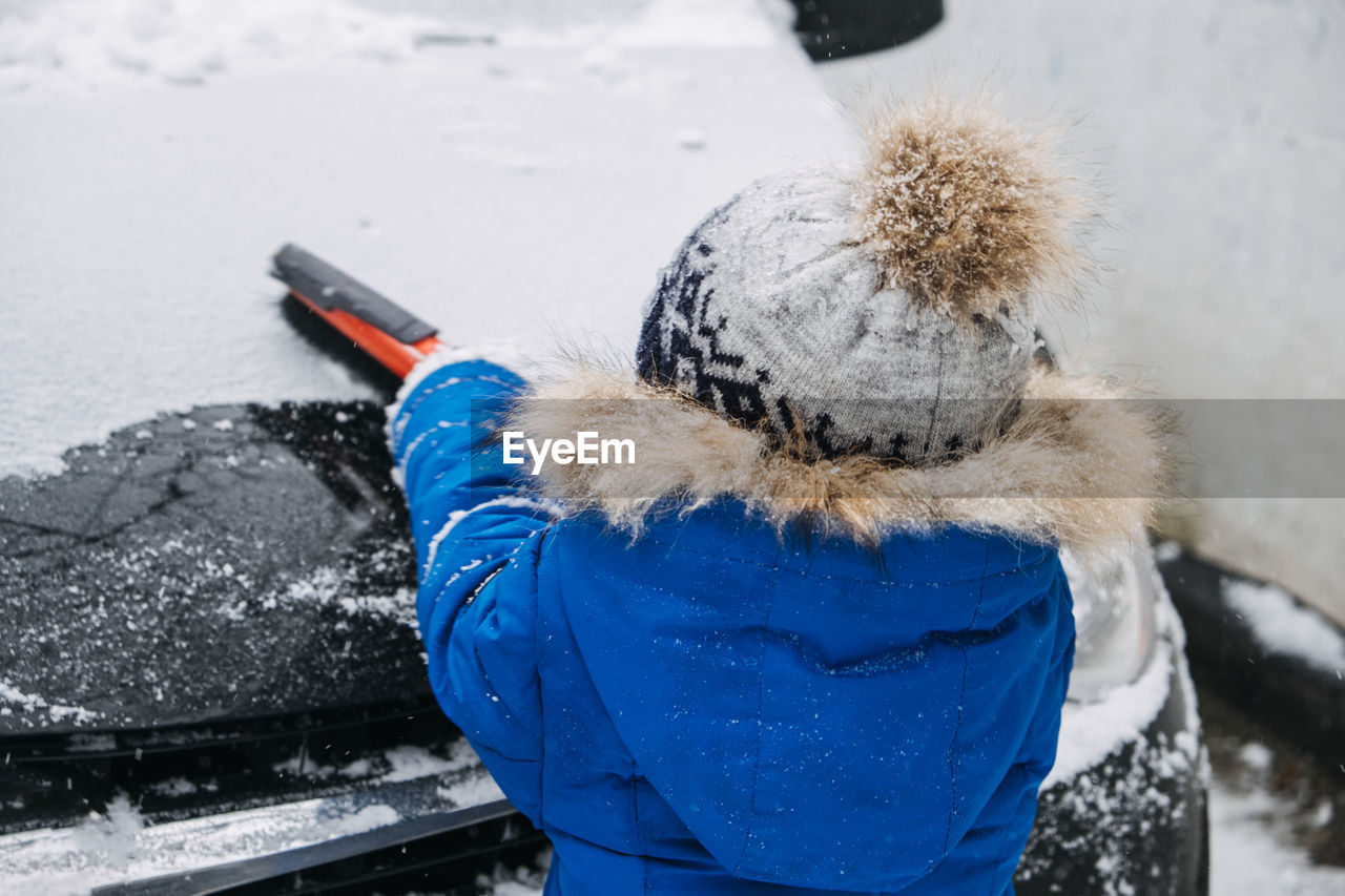 winter, snow, cold temperature, warm clothing, one person, clothing, nature, day, glove, hat, adult, blue, freezing, leisure activity, outdoors, rear view, knit hat, focus on foreground, waist up