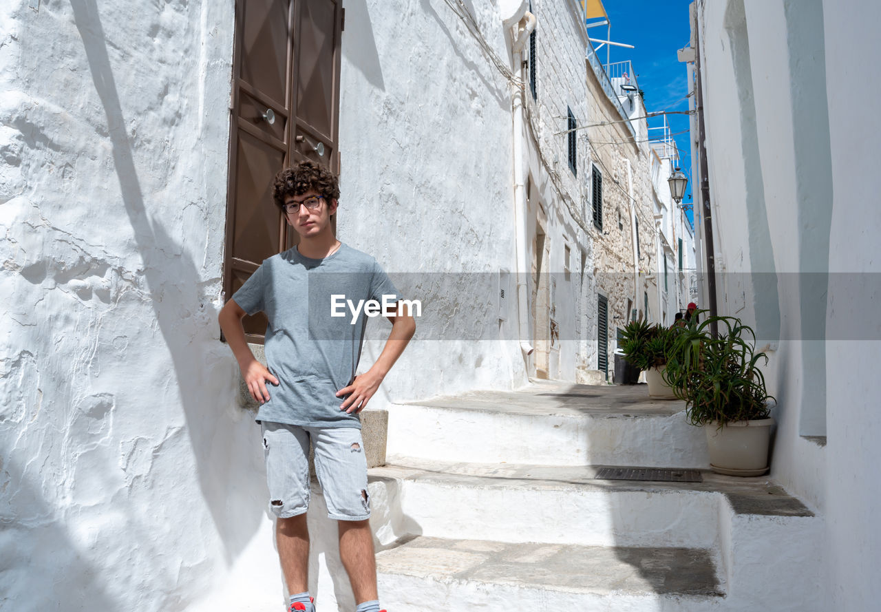 full length of young man standing against building