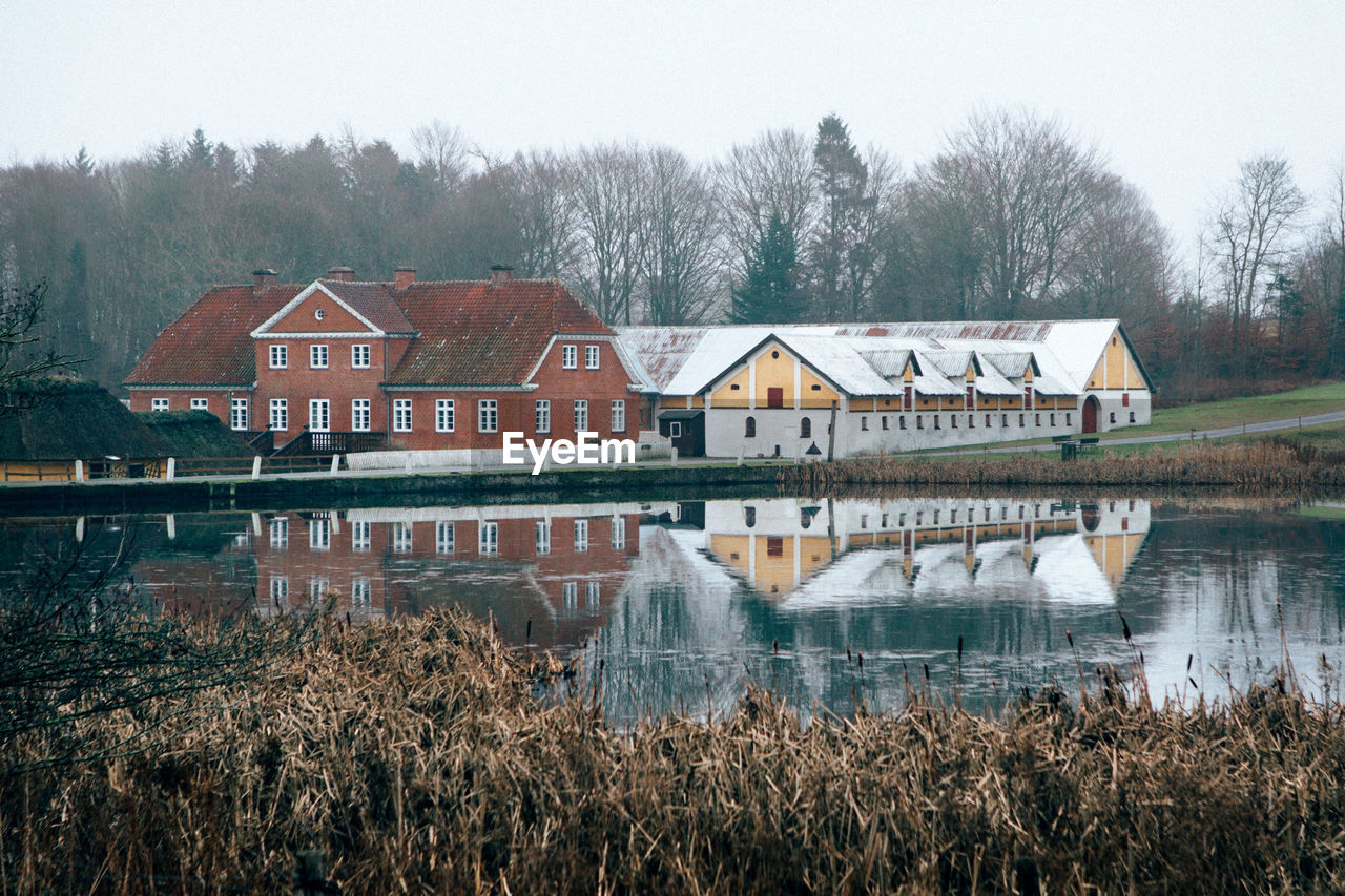 HOUSES ON LAKE AGAINST SKY