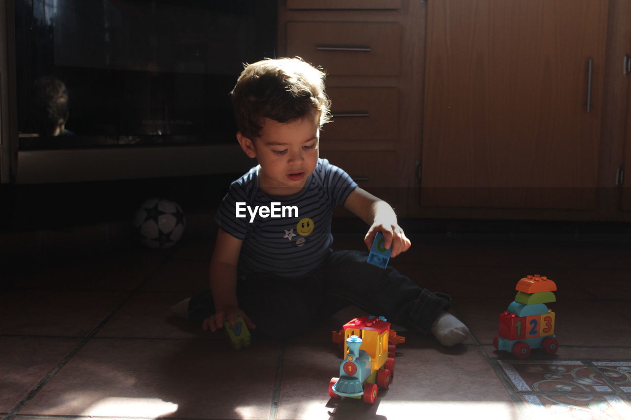 Cute boy playing with toy at home