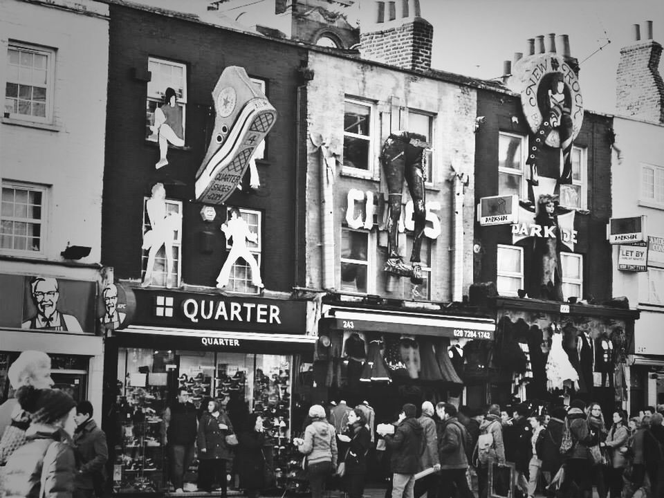 View of people in front of stores at the road