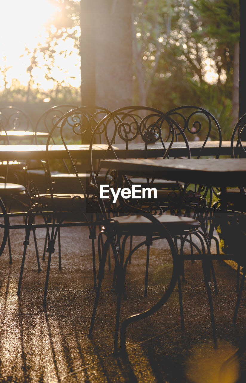 Close-up of empty chairs and table at sidewalk cafe