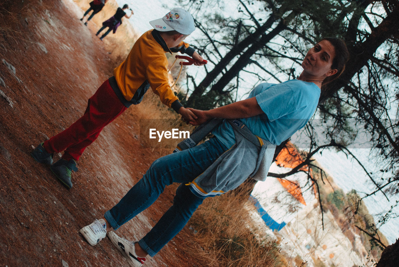 Tilt image of woman with son standing on field