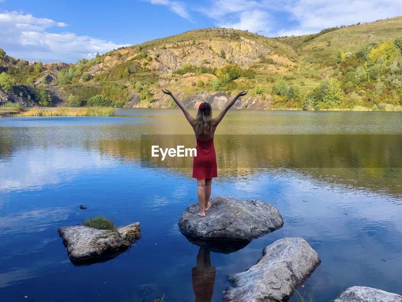 rear view of man with arms raised in lake