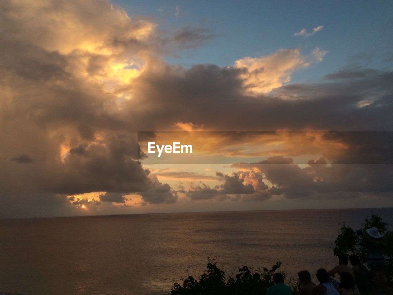 Scenic view of sea against cloudy sky during sunset