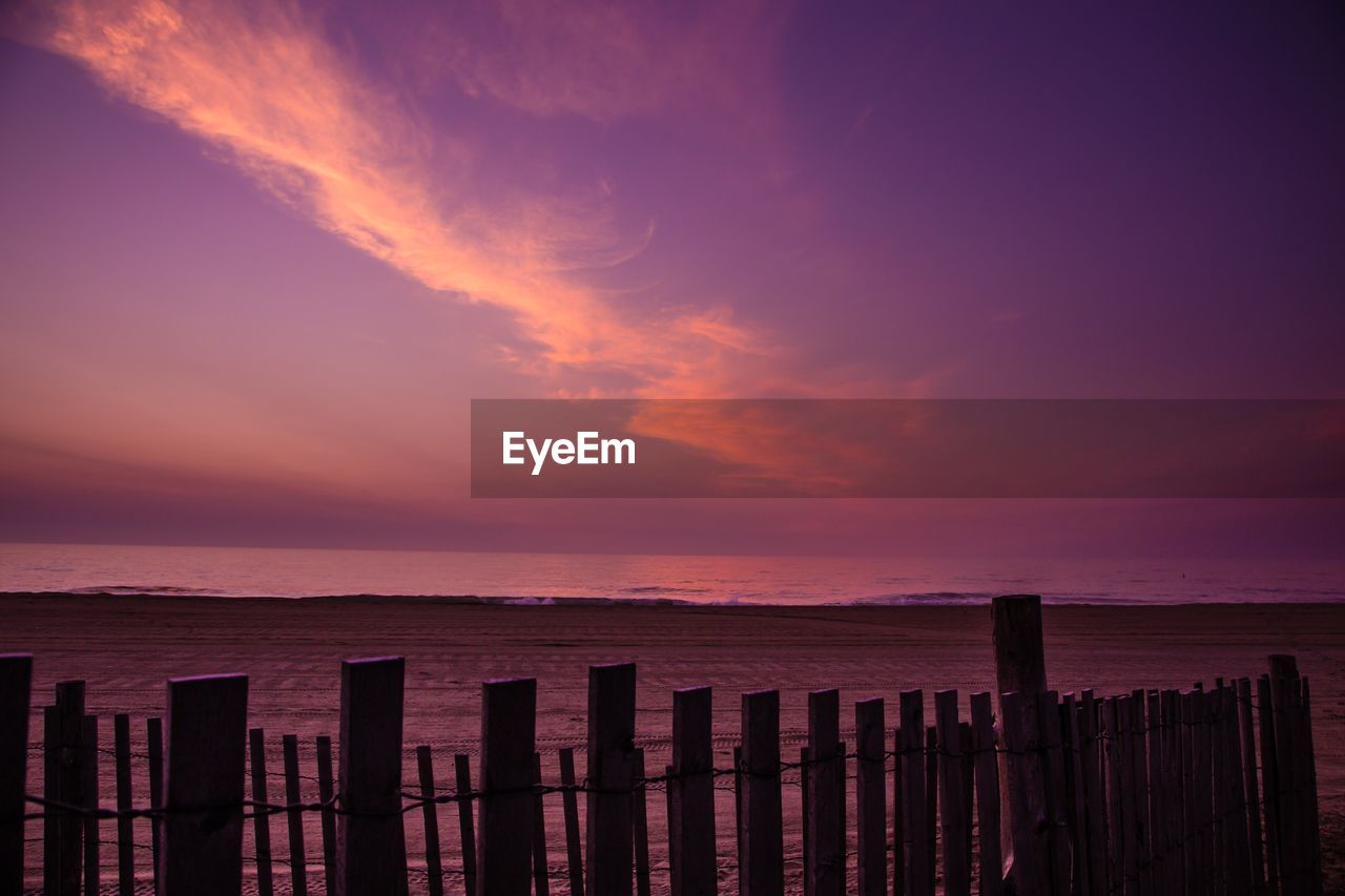SCENIC VIEW OF BEACH AGAINST SKY DURING SUNSET