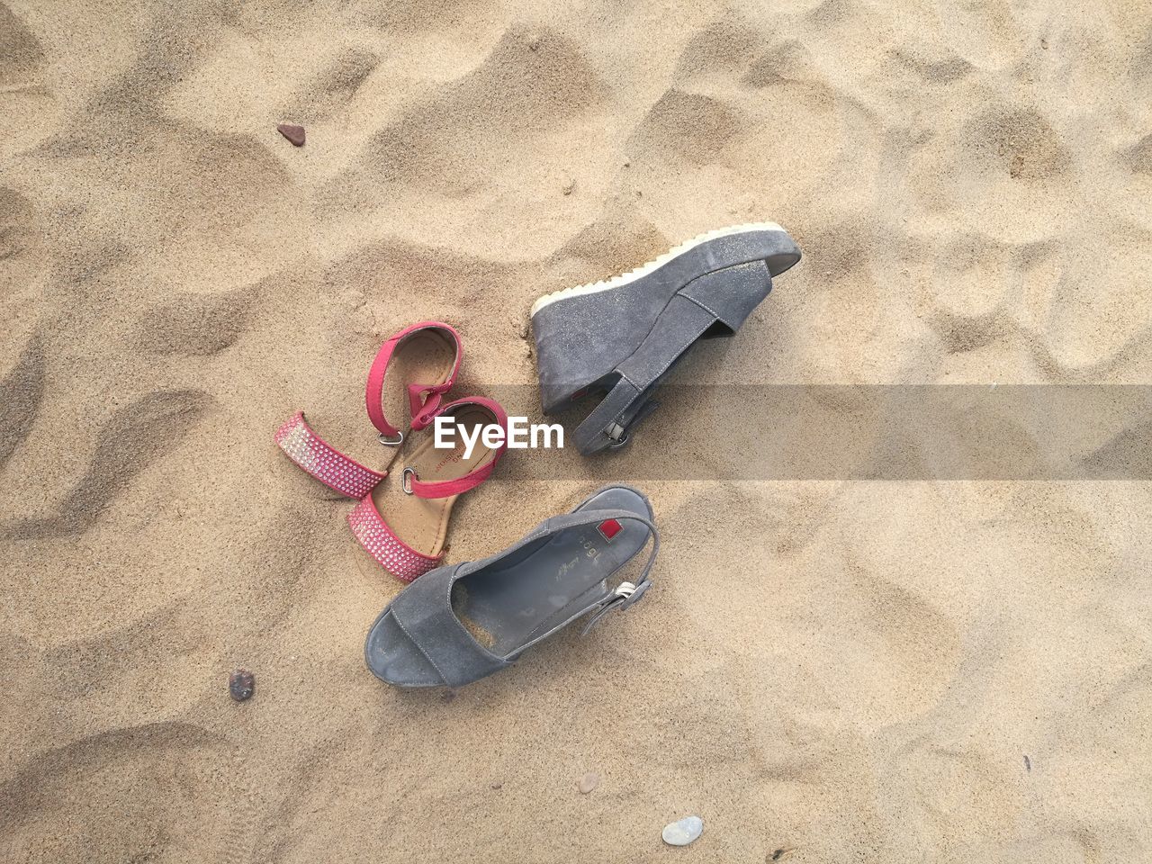 HIGH ANGLE VIEW OF SHOES ON SANDY BEACH