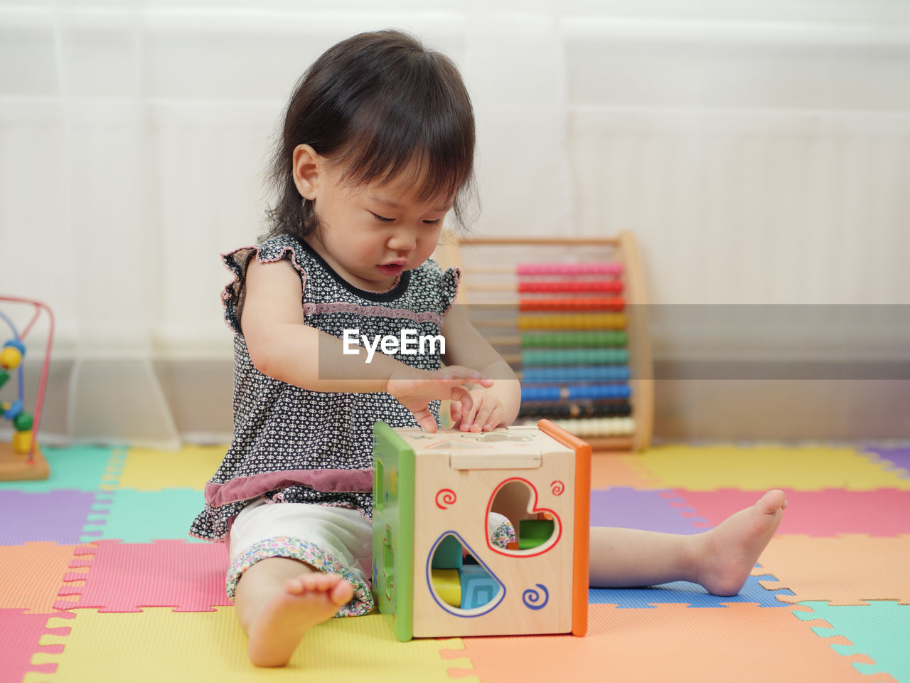 Baby girl playing with toys at home