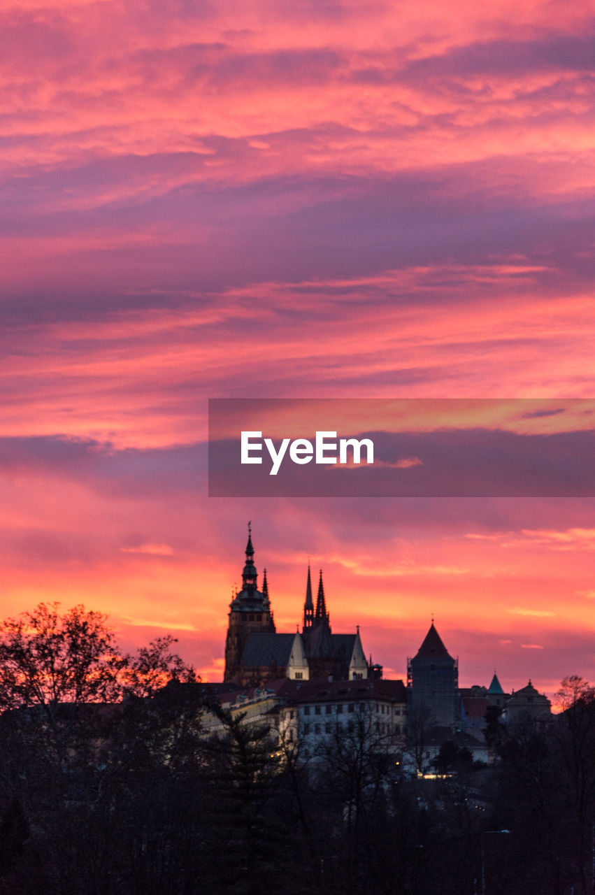 VIEW OF BUILDINGS AGAINST CLOUDY SKY AT SUNSET