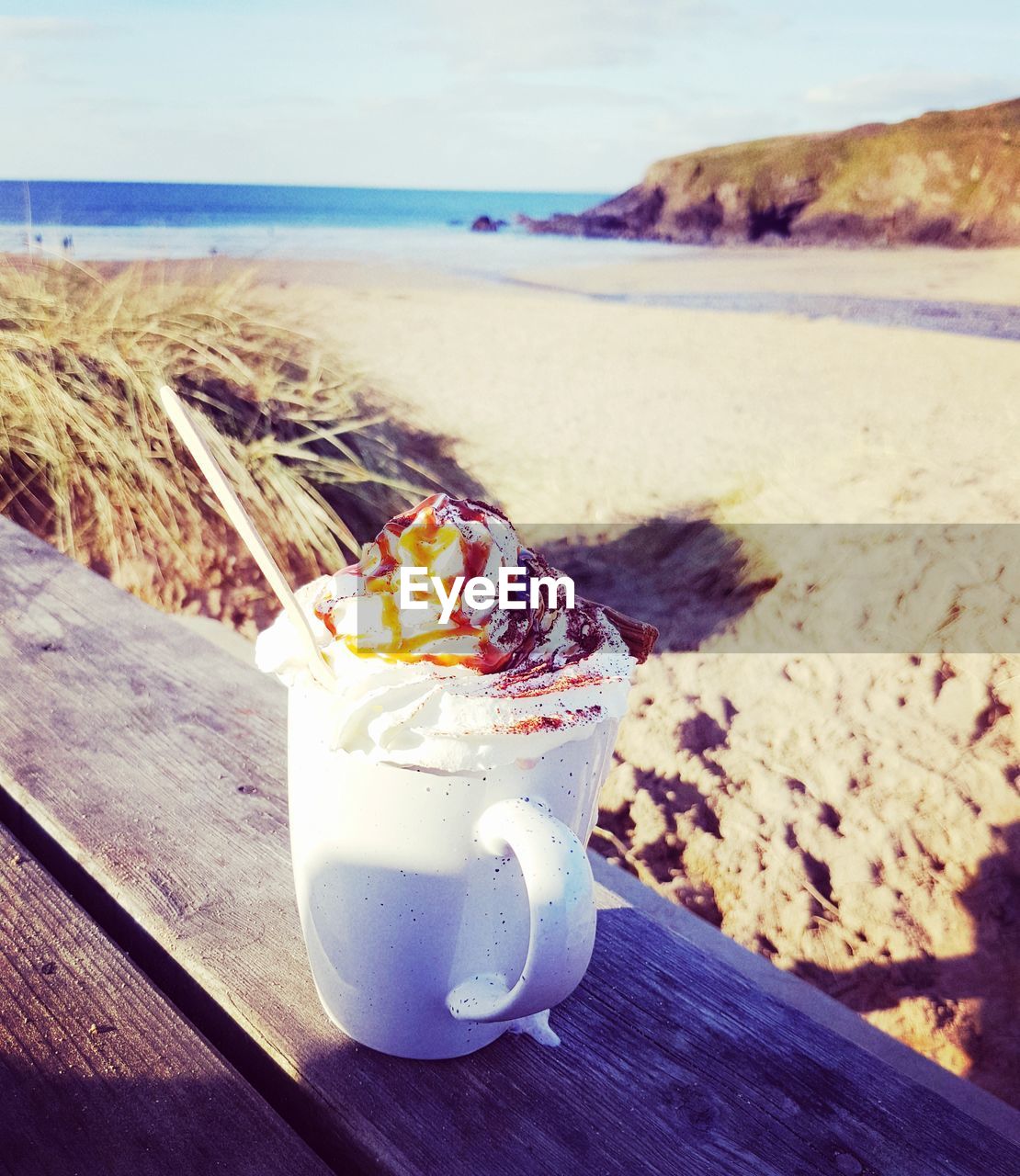 CLOSE-UP OF DRINK ON BEACH