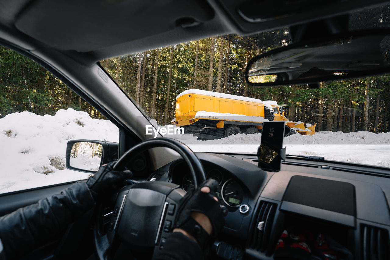 Man in car on winter mountain road