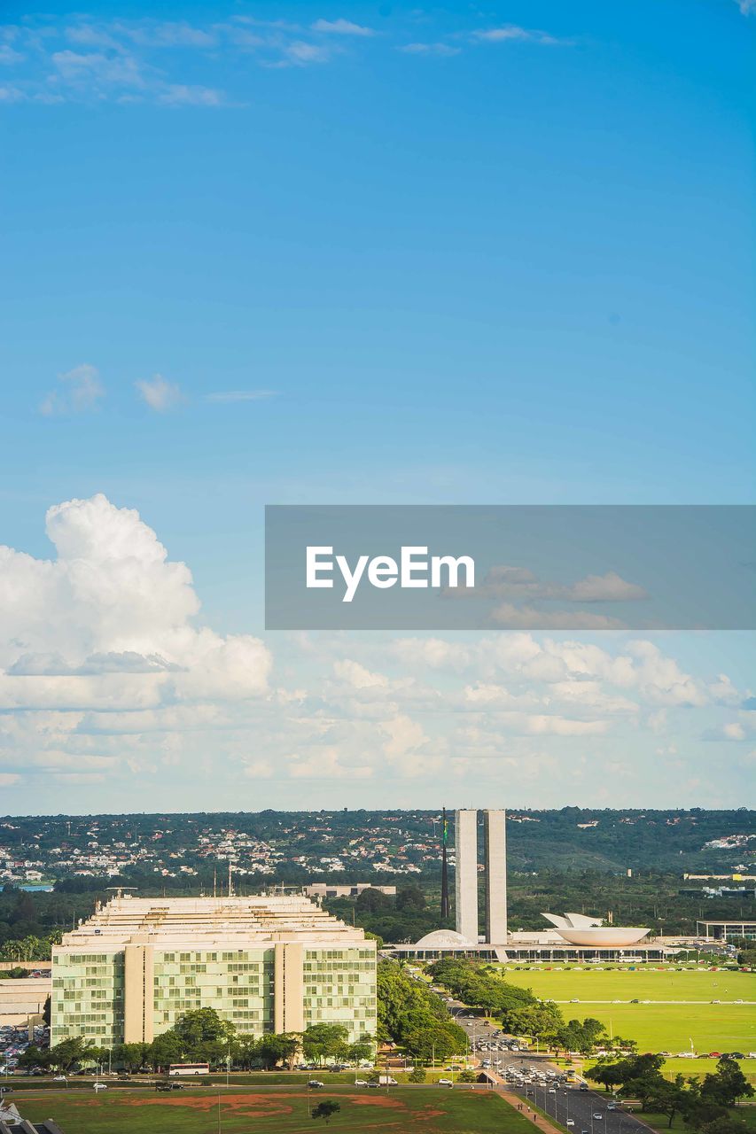 HIGH ANGLE VIEW OF BUILDINGS AGAINST SKY IN CITY