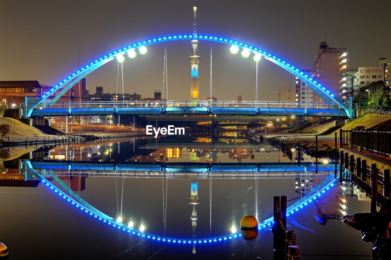 ILLUMINATED BRIDGE AGAINST SKY IN CITY AT NIGHT