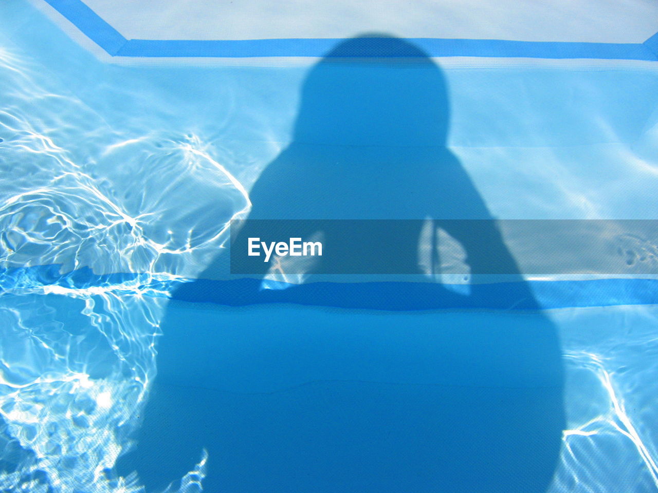 Shadow of person on swimming pool