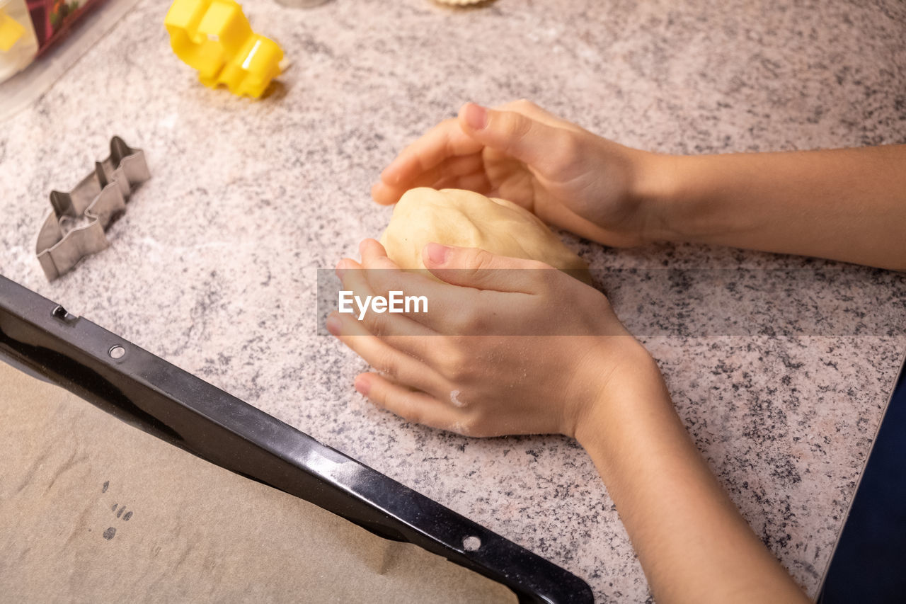 HIGH ANGLE VIEW OF WOMAN HAND HOLDING ICE CREAM IN KITCHEN