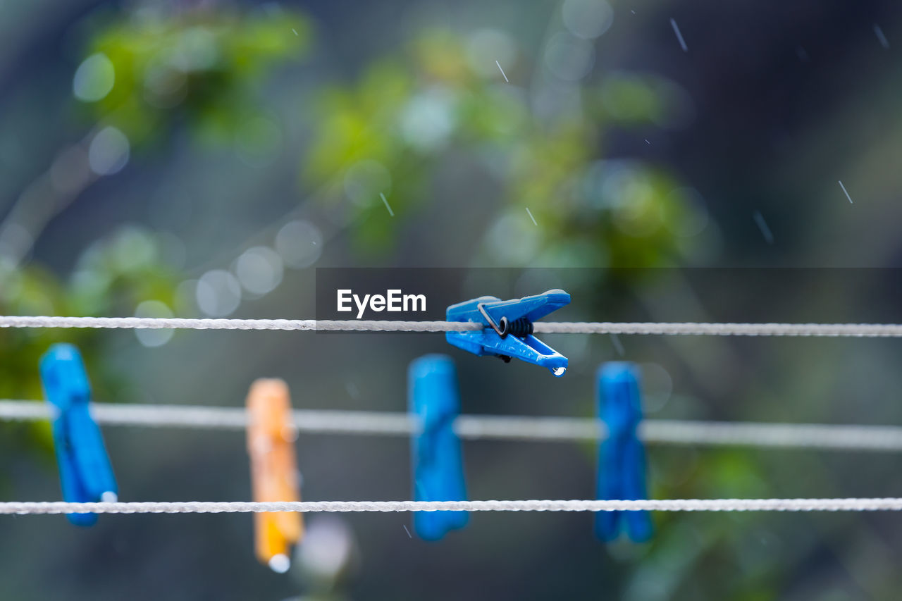 CLOSE-UP OF BLUE ROPE ON METAL FENCE