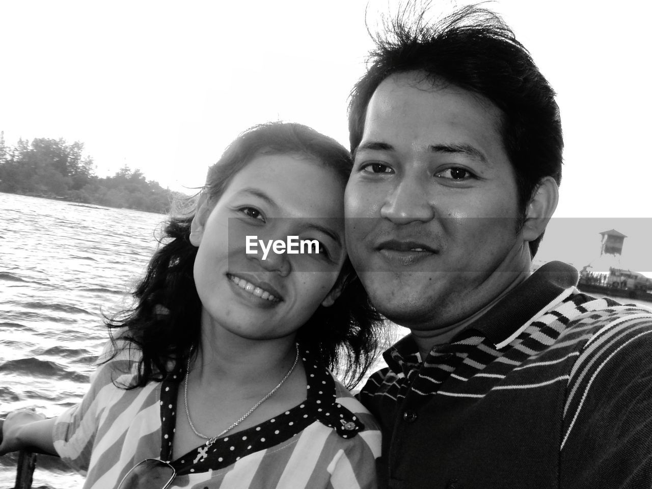 Portrait of couple smiling against sea