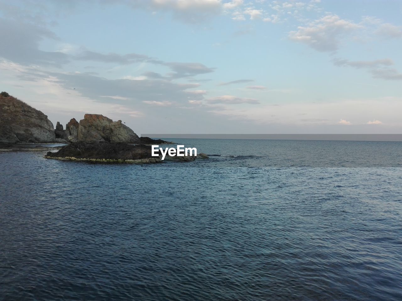 VIEW OF CALM SEA AGAINST CLOUDY SKY