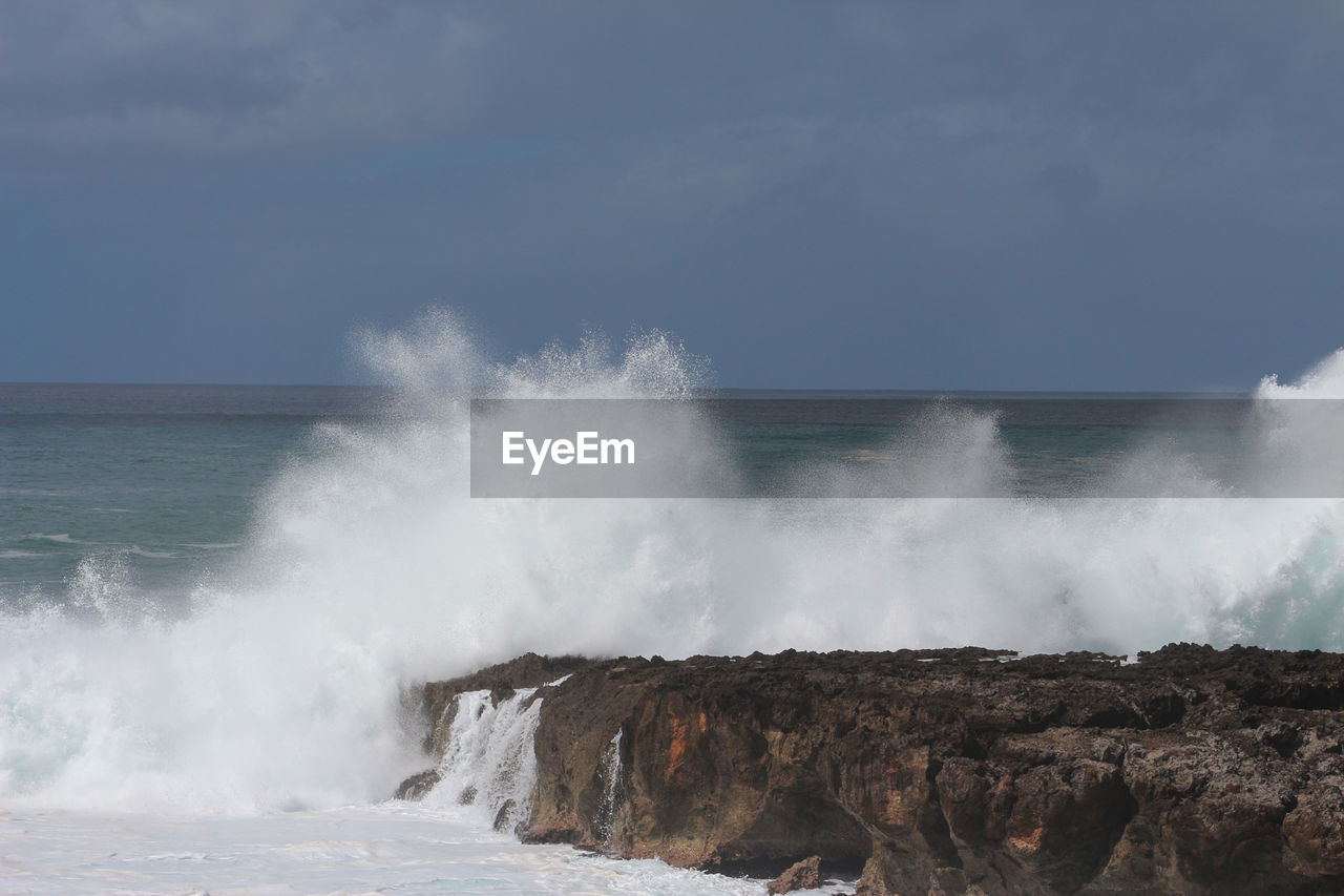 WAVES SPLASHING ON ROCKS AGAINST SEA