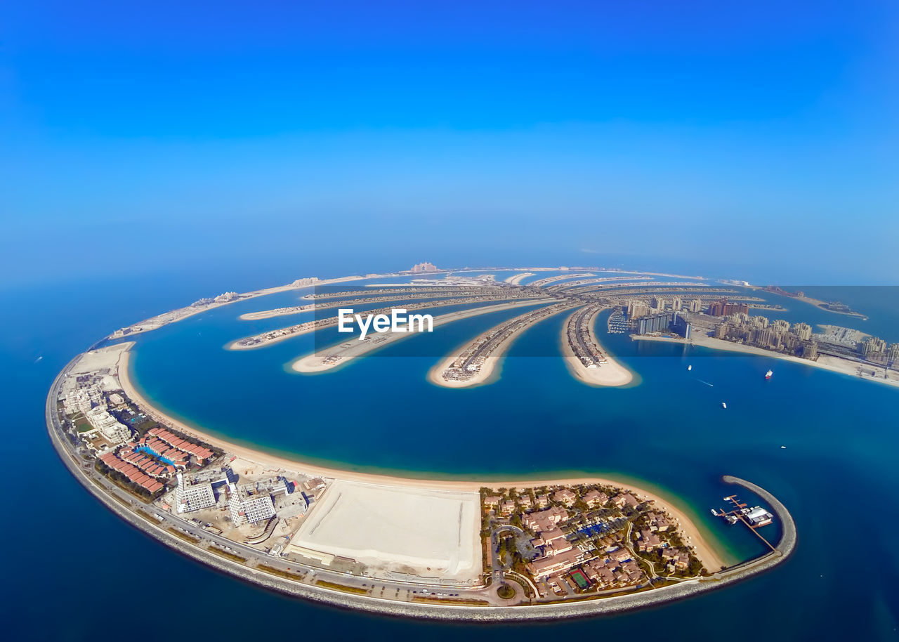 Fish-eye view of palm jumeirah against clear blue sky