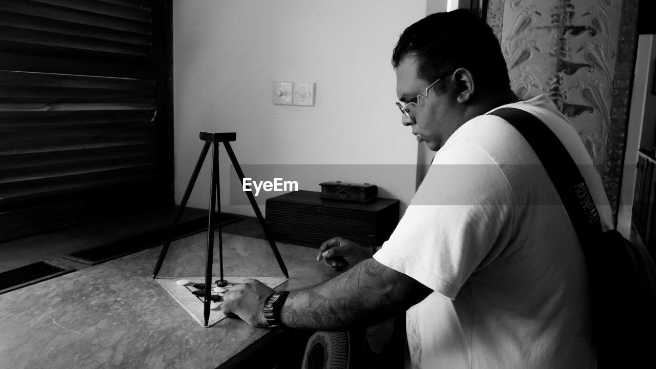 Side view of architect examining equipment while working at home