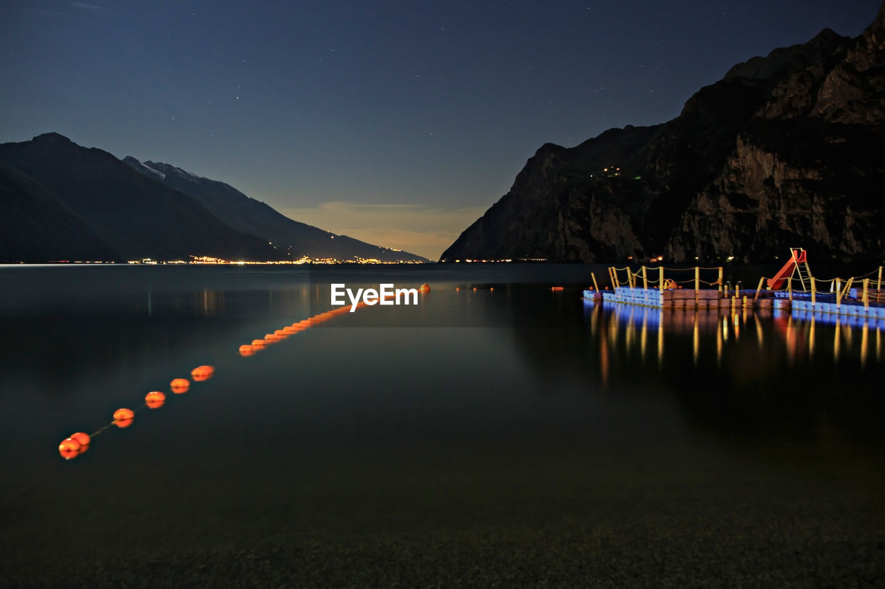 Scenic view of lake against sky at night