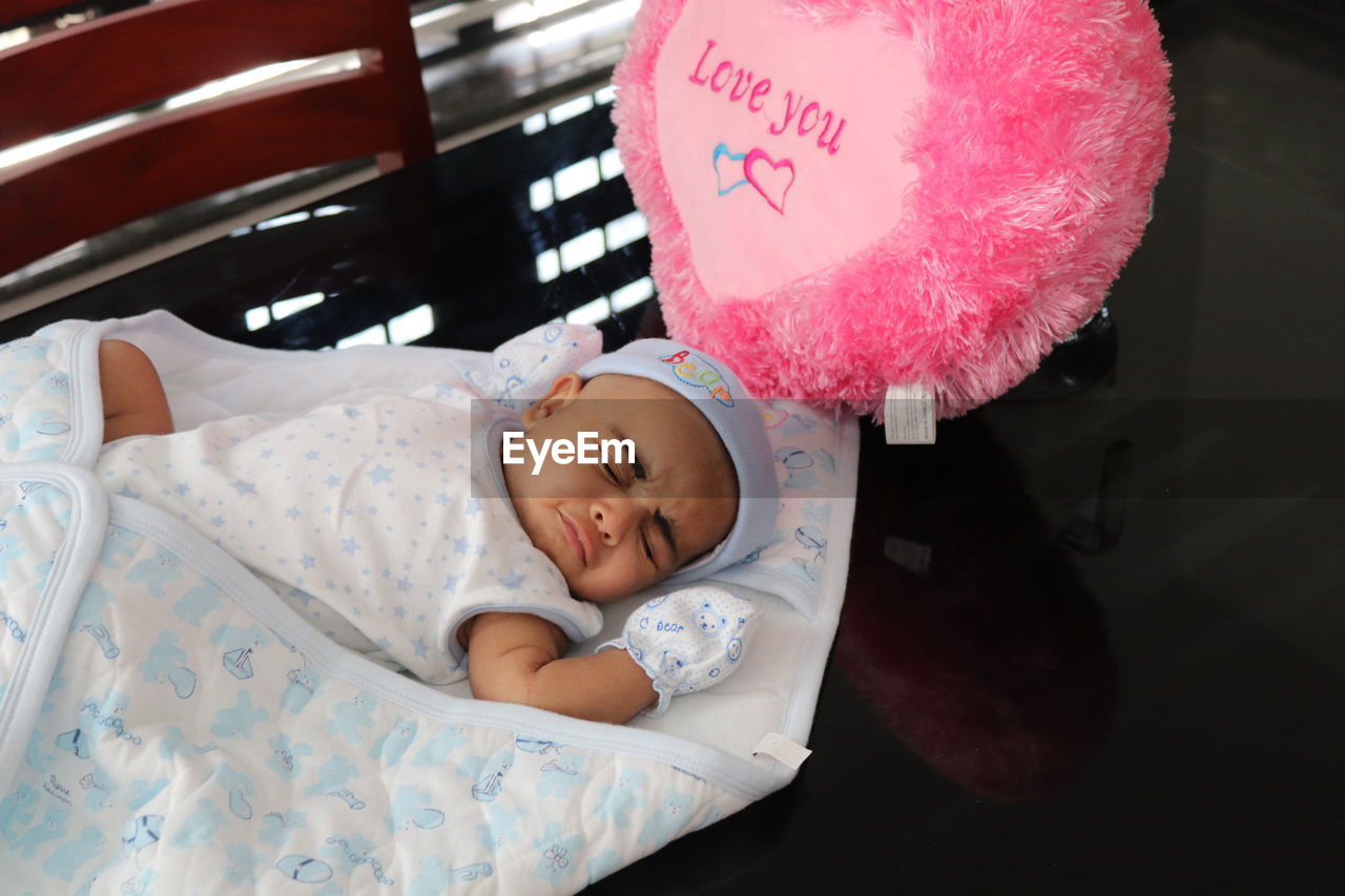 High angle view of baby girl sleeping on table at home