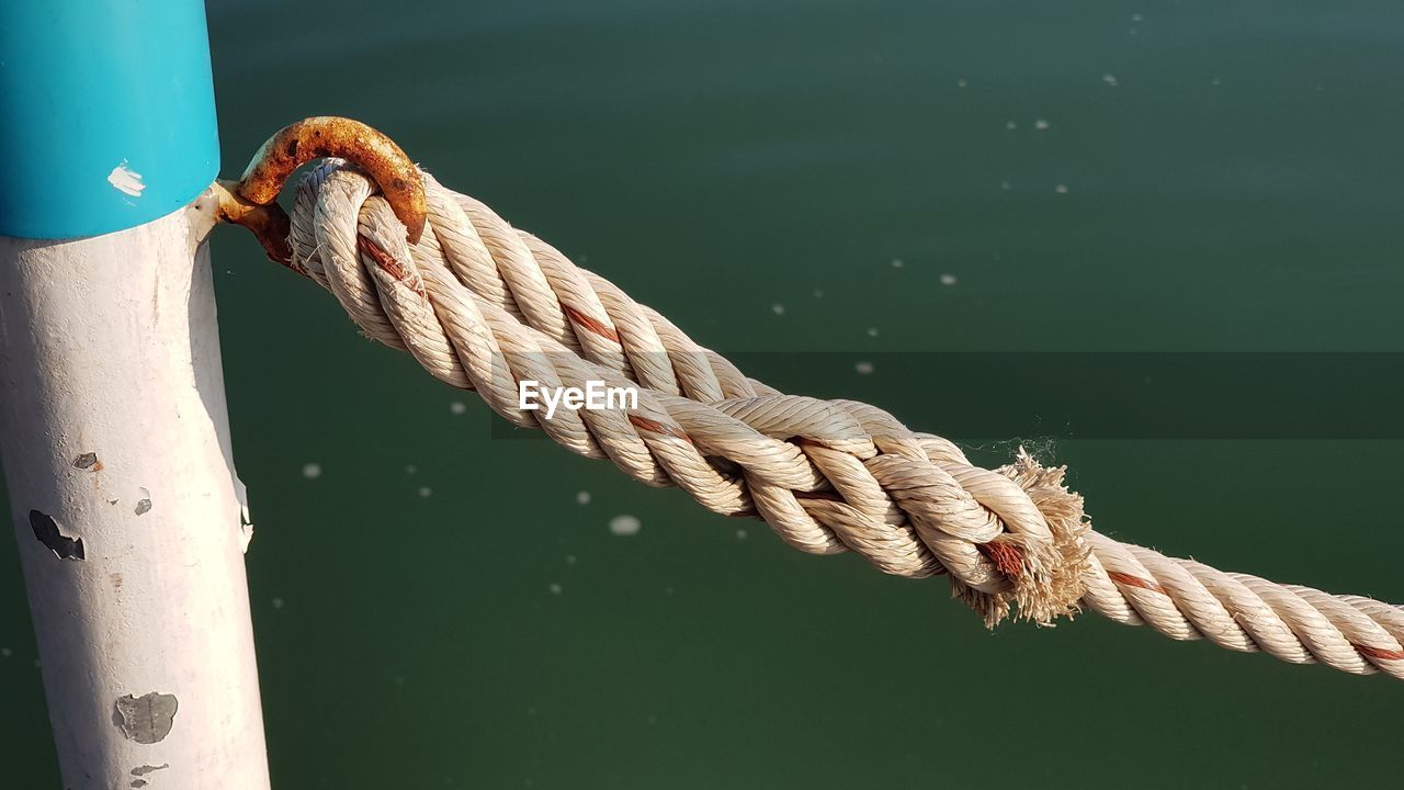 High angle view of rope tied up to pole against sea
