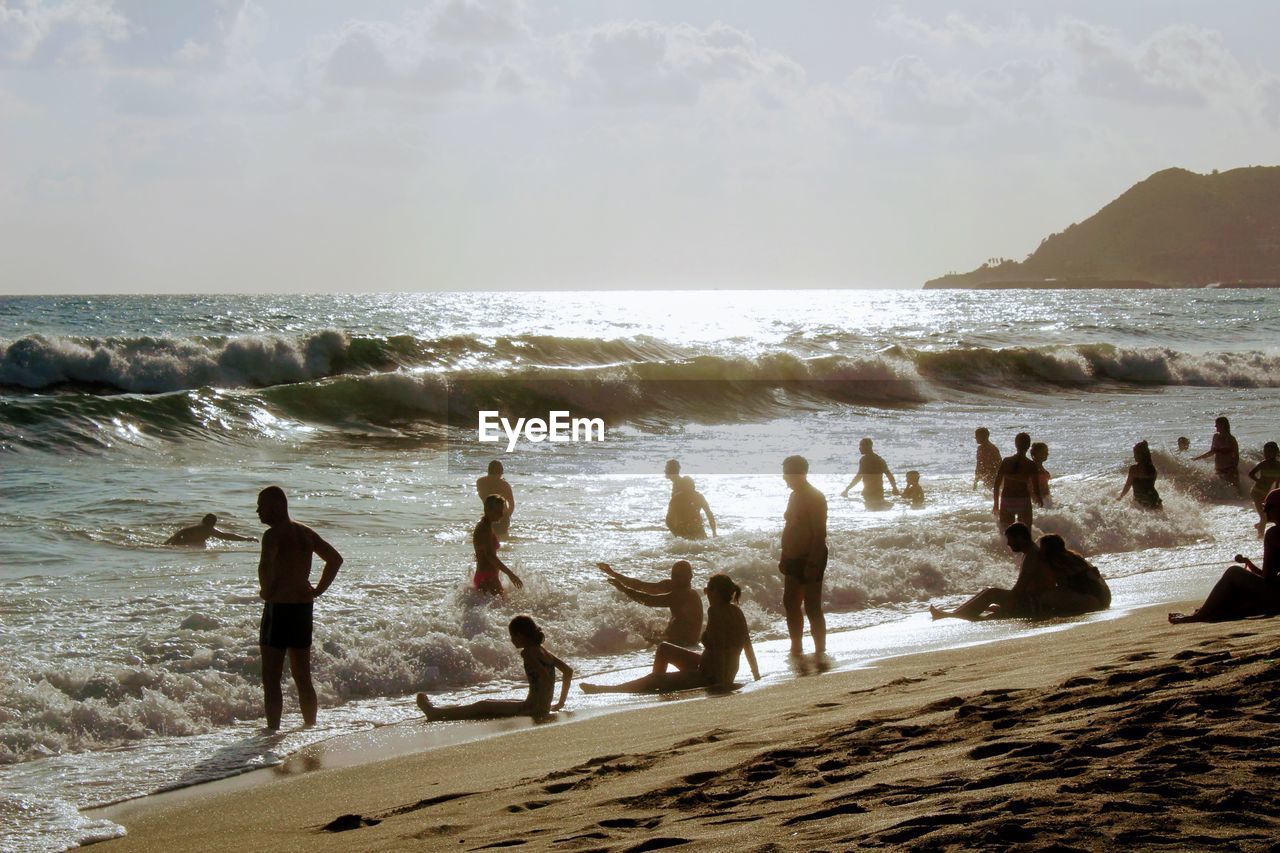 PEOPLE ON BEACH AGAINST SKY