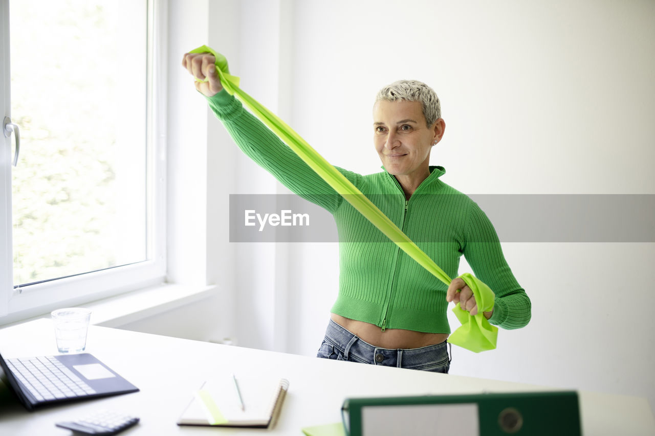 portrait of young woman using digital tablet while standing in office
