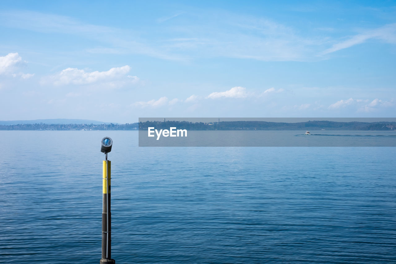 Wooden posts in sea against sky