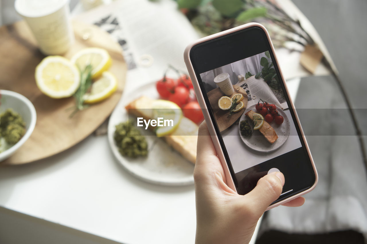 CROPPED IMAGE OF HAND HOLDING FOOD SERVED IN PLATE