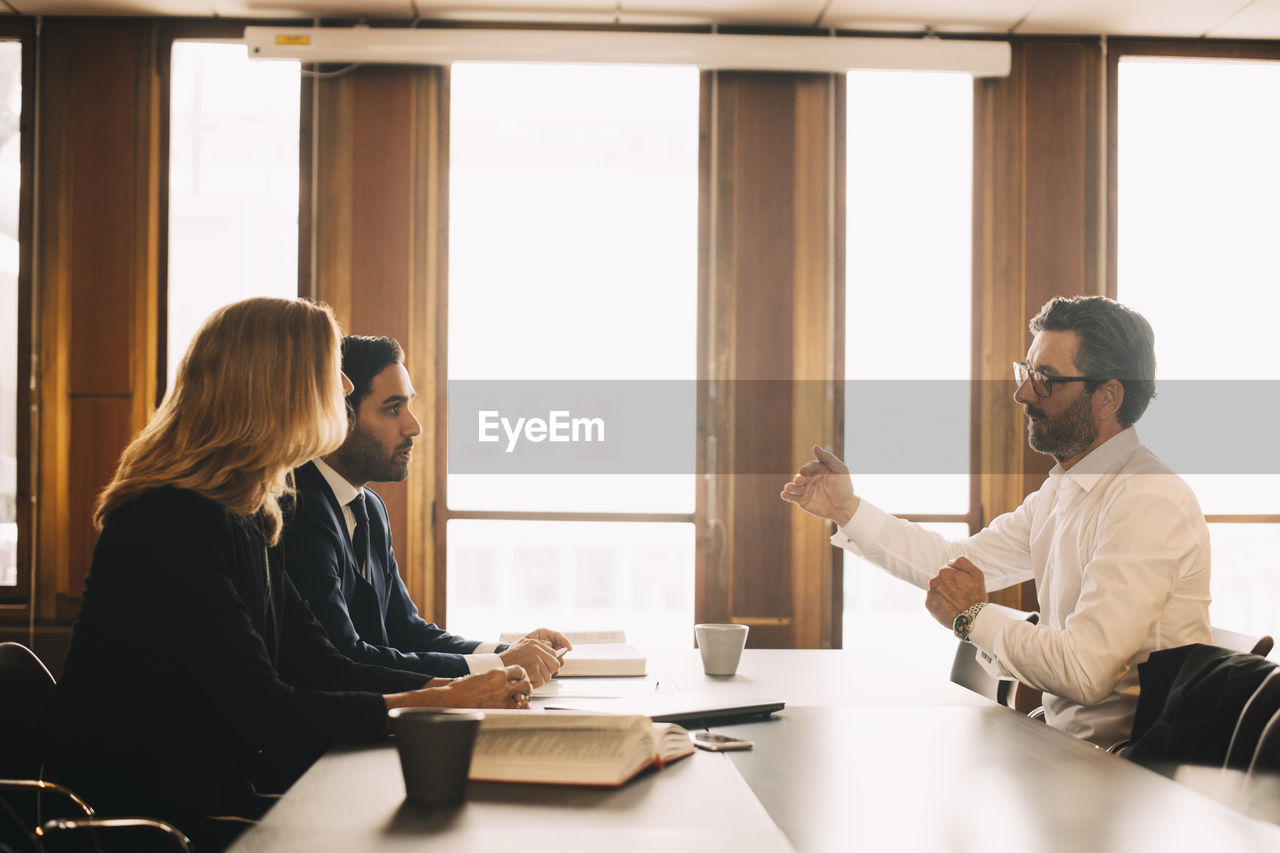 Businessman explaining problems to lawyers in meeting at office