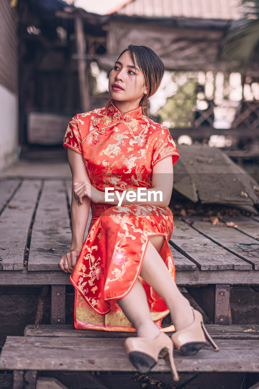 Woman looking away while sitting outdoors