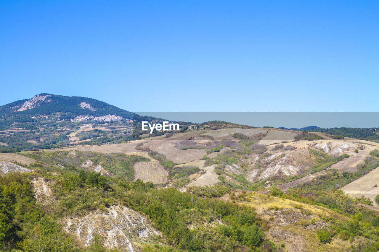 SCENIC VIEW OF LANDSCAPE AND MOUNTAINS AGAINST CLEAR BLUE SKY